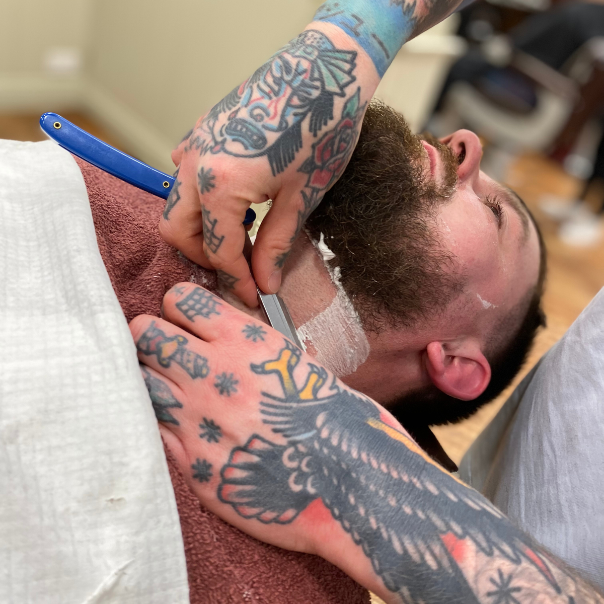 Barber giving a traditional cut-throat razor shave at Swagger & Jacks, Norwich
