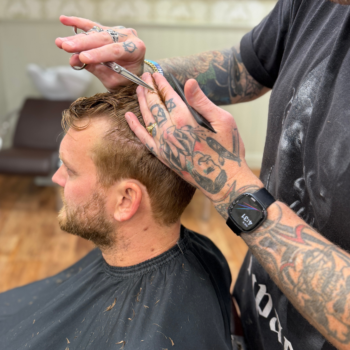 Master Barber cutting a client's hair with scissors at Swagger & Jacks barbershop, Norwich